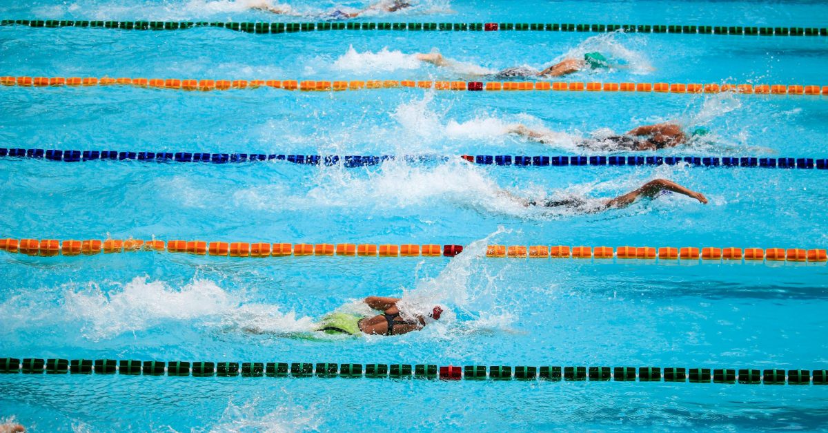 pexels photo 1263349 1263349 Swimmers compete in an outdoor pool race, showcasing athleticism and sportsmanship.